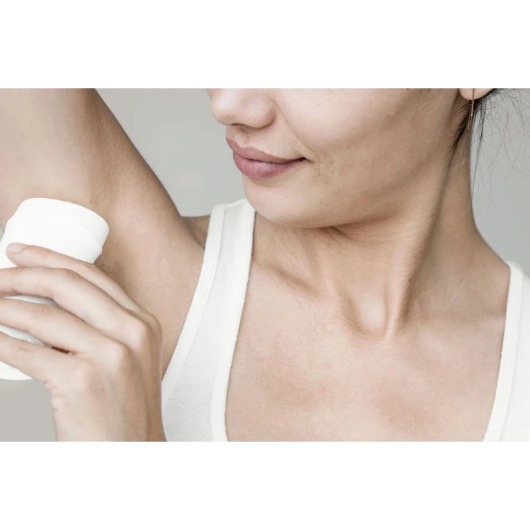 Vrouw gebruikt natuurlijke deodorant zonder aluminium op haar oksel